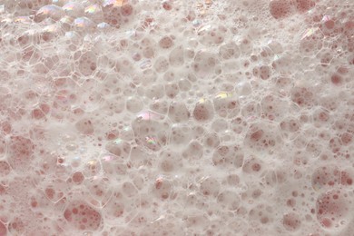 White washing foam on pale pink background, top view