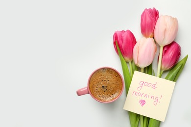 Photo of Cup of aromatic coffee, beautiful pink tulips and Good Morning note on white marble table, flat lay. Space for text