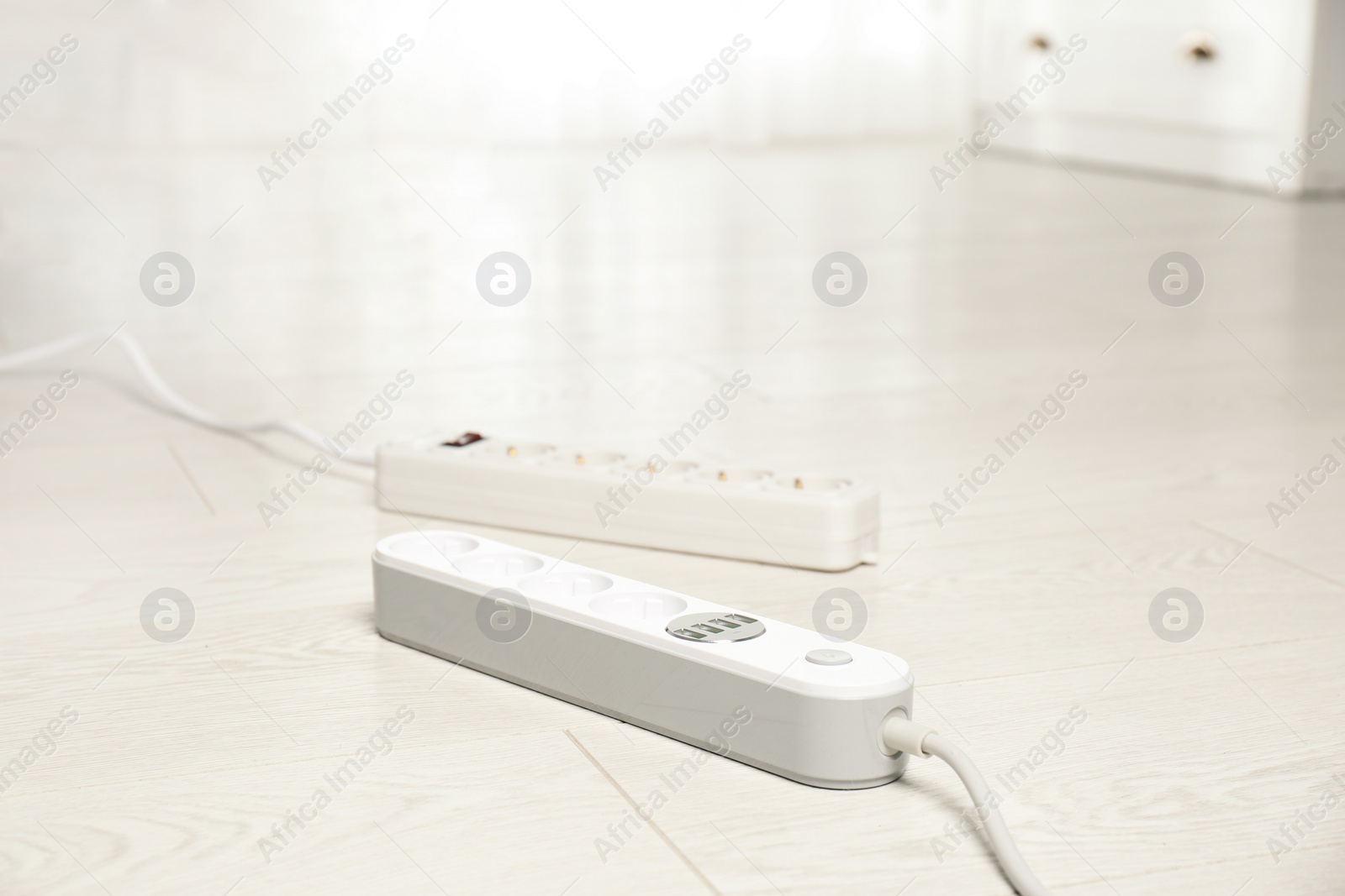 Photo of Extension cords on floor indoors, space for text. Electrician's professional equipment