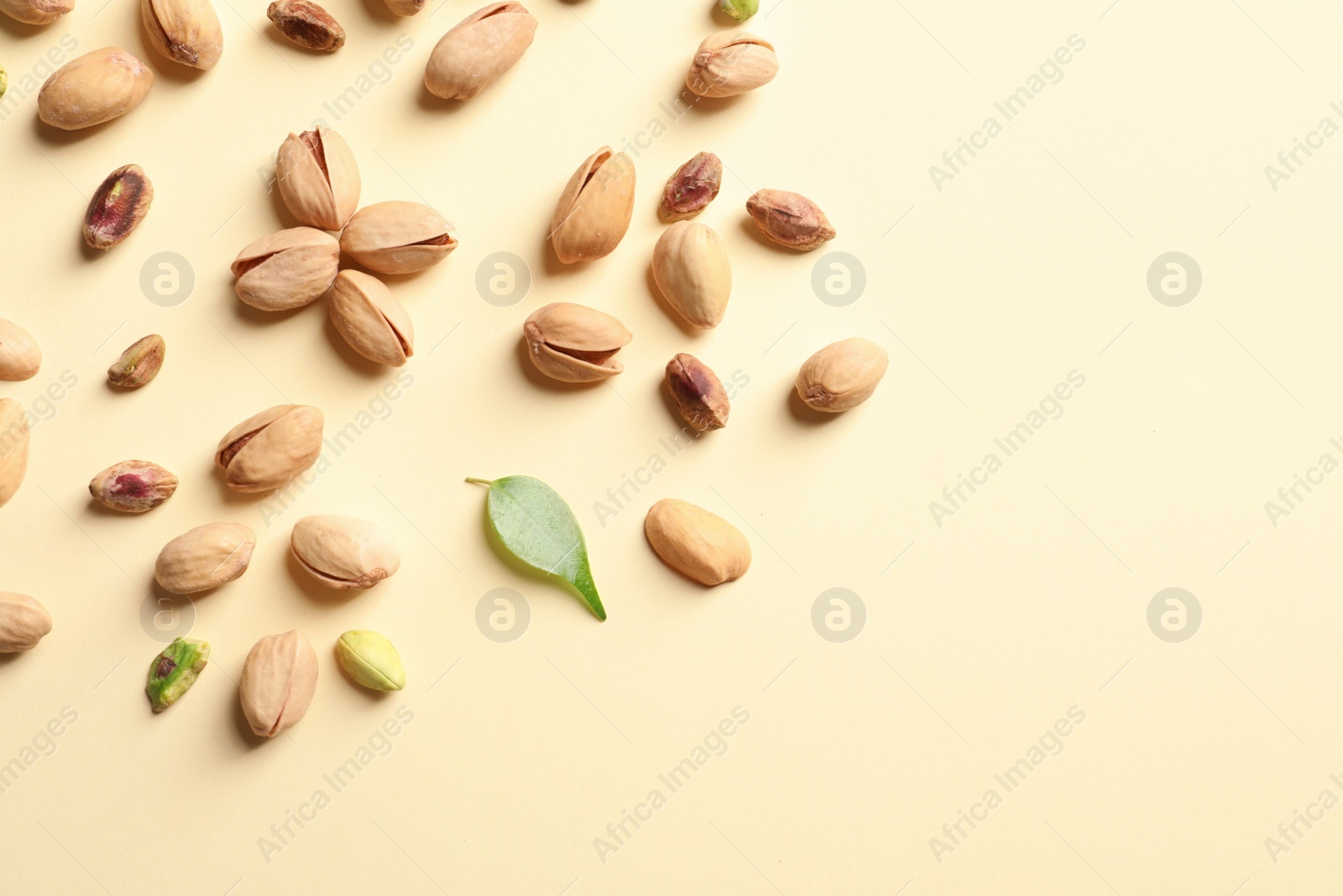 Photo of Composition with organic pistachio nuts on color background, flat lay. Space for text