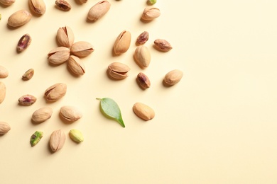 Composition with organic pistachio nuts on color background, flat lay. Space for text
