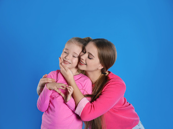 Photo of Happy mother and little daughter on blue background