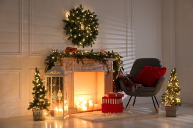 Photo of Beautiful Christmas themed photo zone with fireplace and fir decor