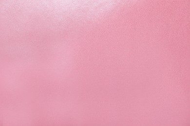 Pink wrapping paper as background, top view
