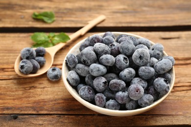 Tasty frozen blueberries on wooden table, closeup