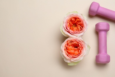 Photo of 8 March greeting card design with roses, dumbbells and space for text on beige background, flat lay. International Women's day