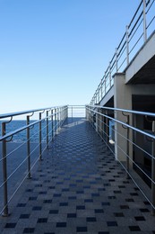 Photo of Modern terrace with metal railings and stairs near sea