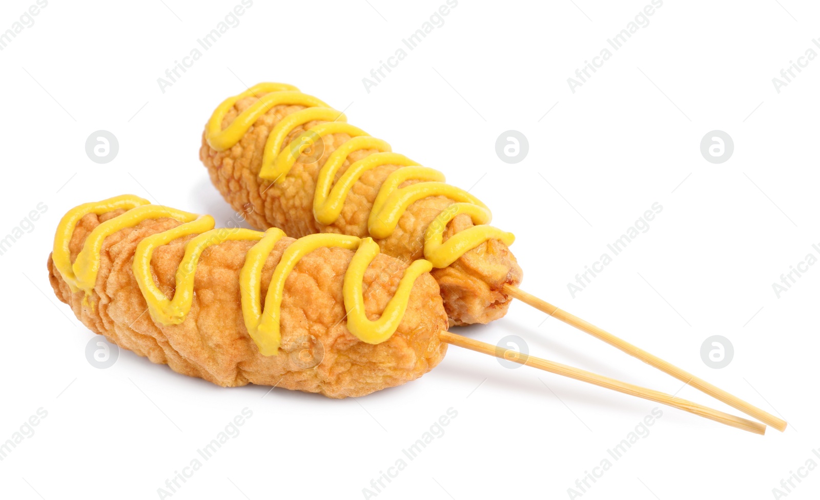 Photo of Delicious deep fried corn dogs with mustard on white background