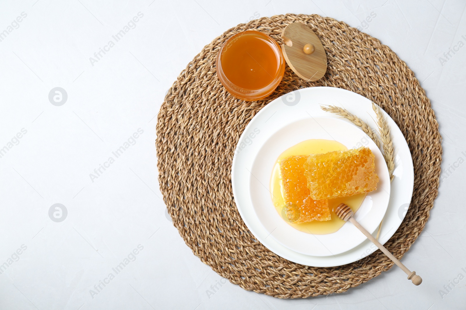 Photo of Natural honeycombs with tasty honey and dipper on white table, top view. Space for text