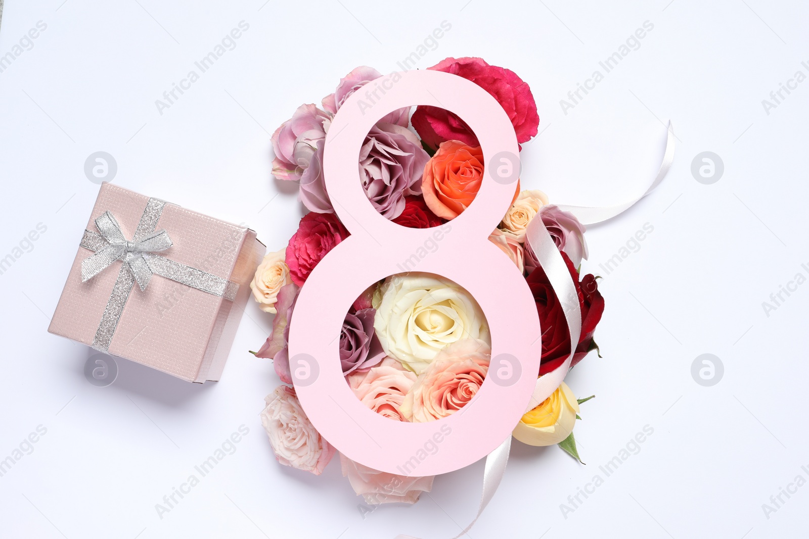 Photo of 8 March greeting card design with roses and gift box on white background, top view. Happy International Women's Day