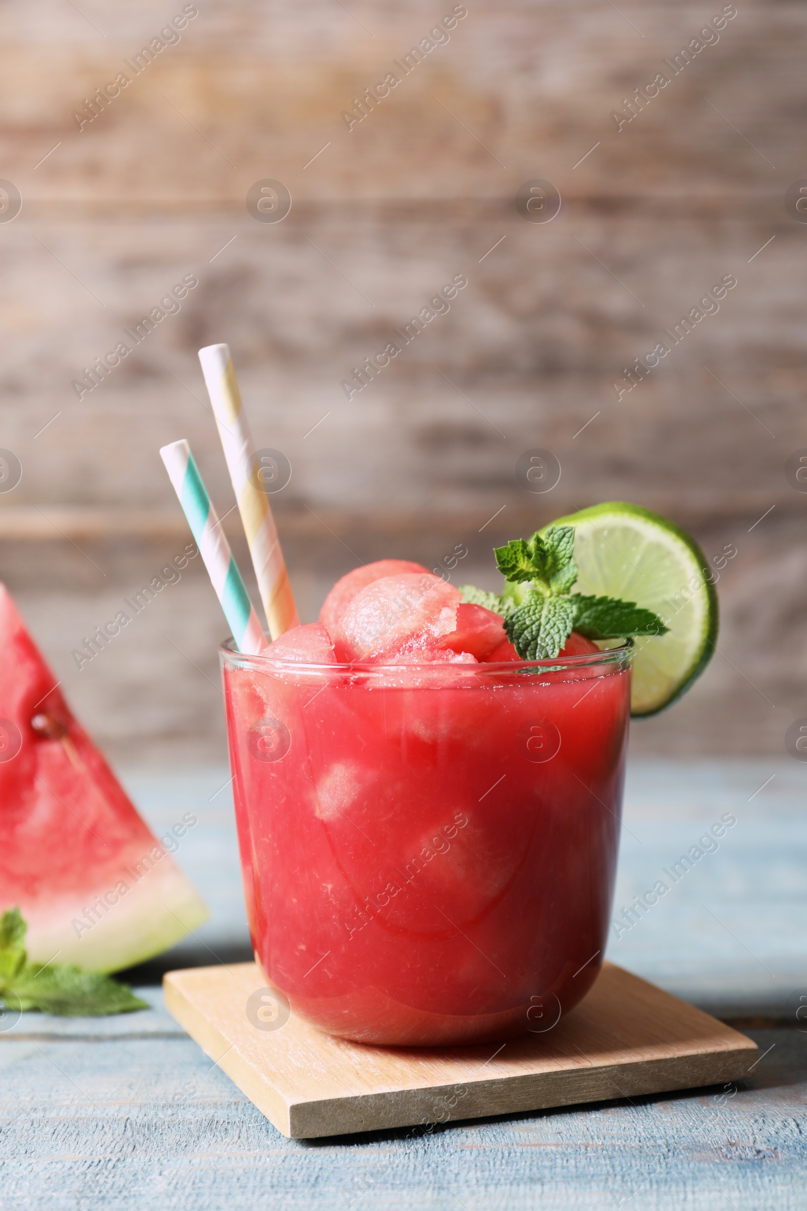 Photo of Summer watermelon drink with lime and mint in glass on table