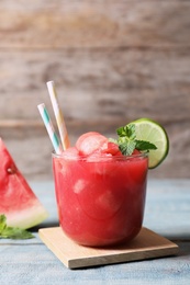 Photo of Summer watermelon drink with lime and mint in glass on table