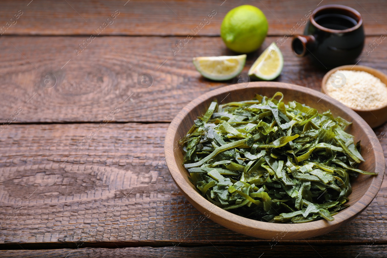 Photo of Fresh laminaria (kelp) seaweed served on wooden table. Space for text