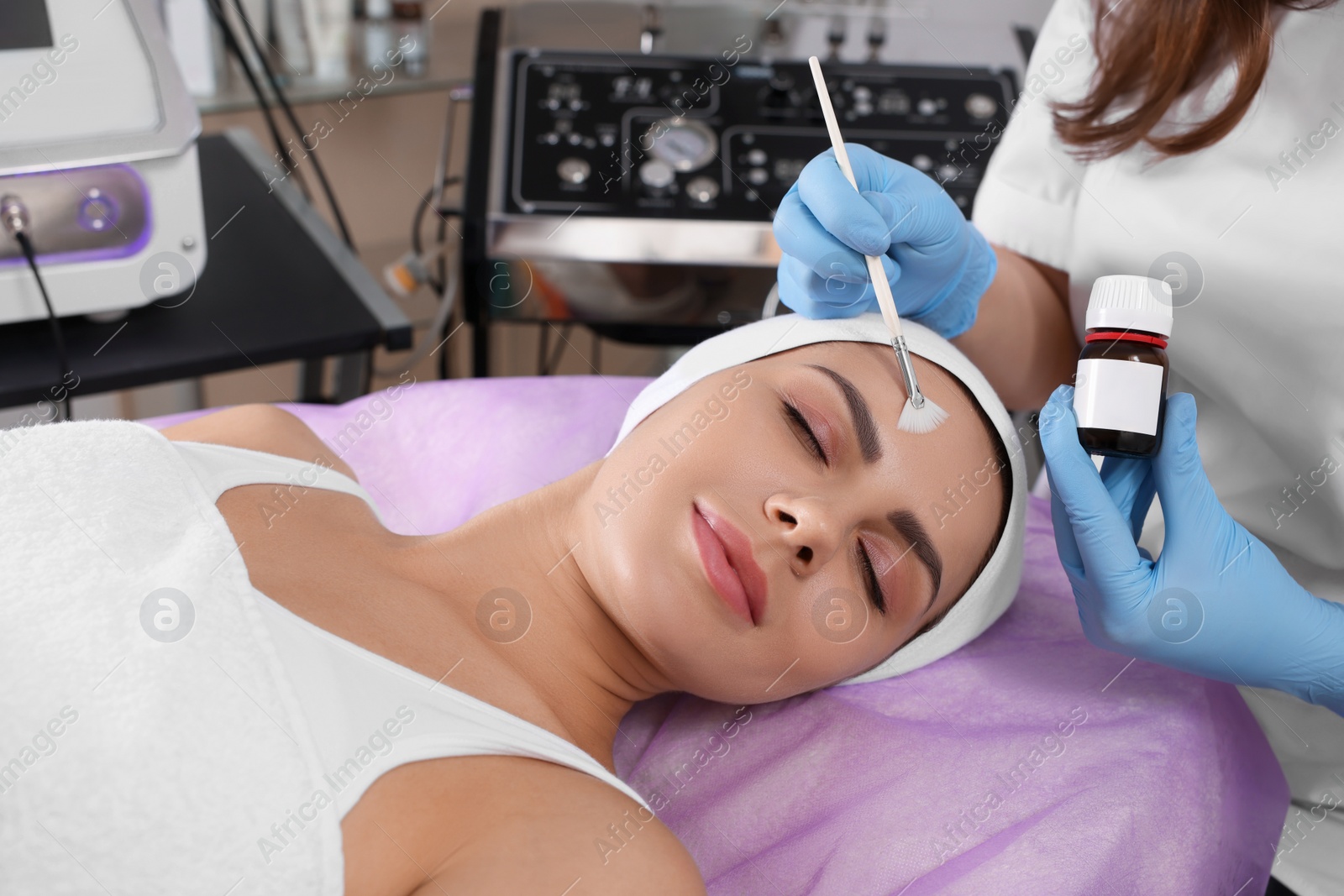 Photo of Young woman undergoing cosmetic procedure in beauty salon