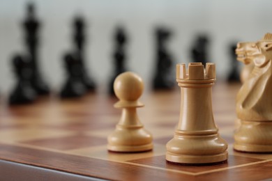 Photo of White wooden pawn, rook and knight on chess board, selective focus. Space for text