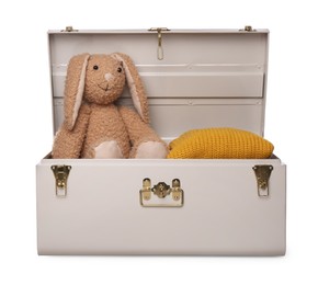 Stylish storage trunk with clothes and toy bunny isolated on white