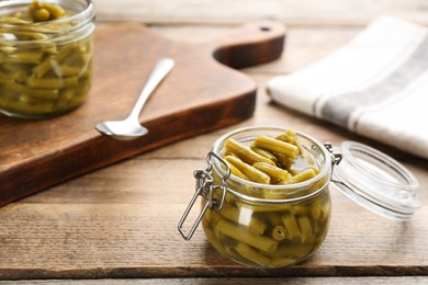 Canned green beans in jar on wooden table