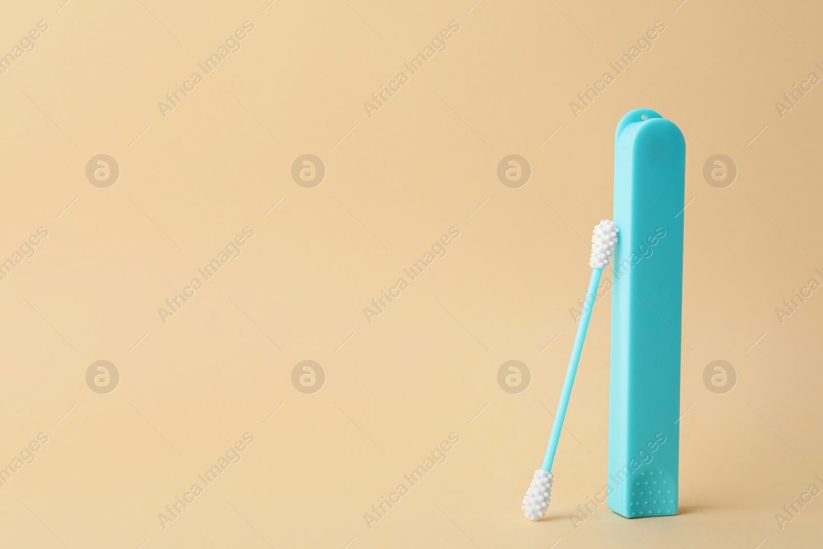 Photo of Reusable ear swab with case on beige background, space for text. Conscious consumption