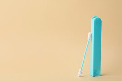 Photo of Reusable ear swab with case on beige background, space for text. Conscious consumption