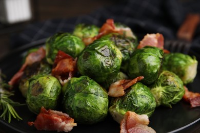 Photo of Delicious roasted Brussels sprouts and bacon on plate, closeup