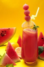 Photo of Tasty watermelon drink and fresh fruits on yellow background