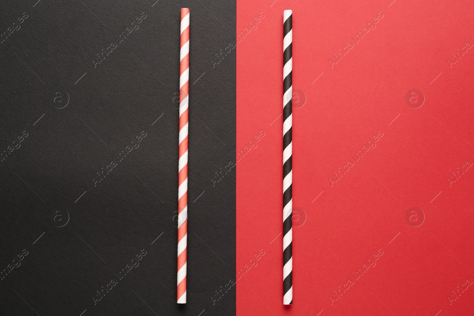 Photo of Striped drinking straws on color background, flat lay