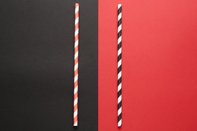 Photo of Striped drinking straws on color background, flat lay