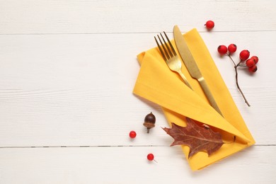 Napkin, cutlery and berries on white wooden background, flat lay with space for text. Stylish autumn table setting