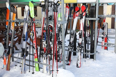 Photo of Stands with ski equipment for rent outdoors. Winter vacation