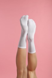 Photo of Woman in stylish white socks on pink background, closeup