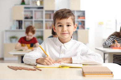 Photo of Portrait of cute little boy studying in classroom at school