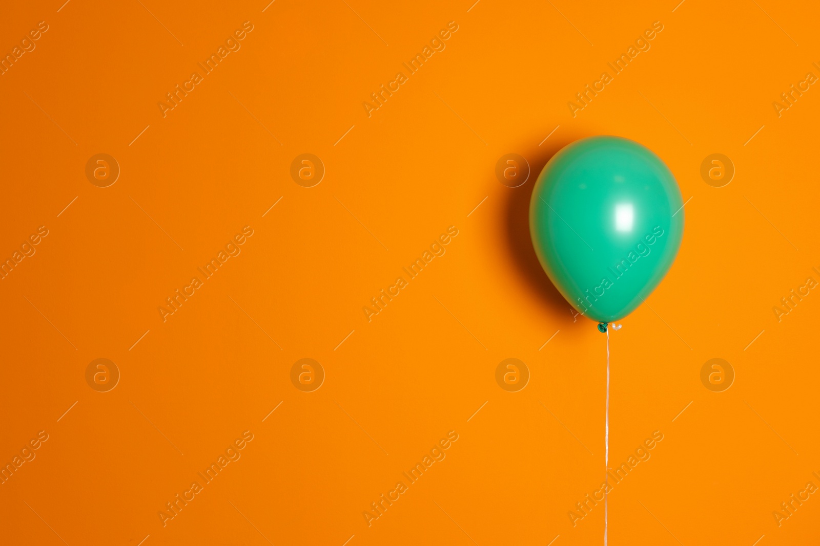 Photo of Green balloon on color background. Celebration time