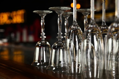 Photo of Different empty clean glasses on counter in bar