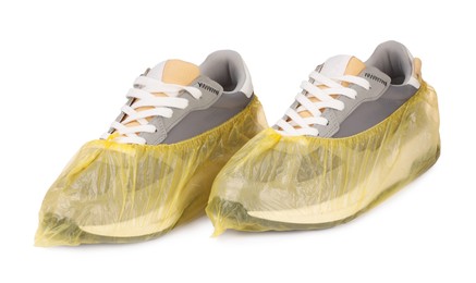 Photo of Men's sneakers in yellow shoe covers isolated on white