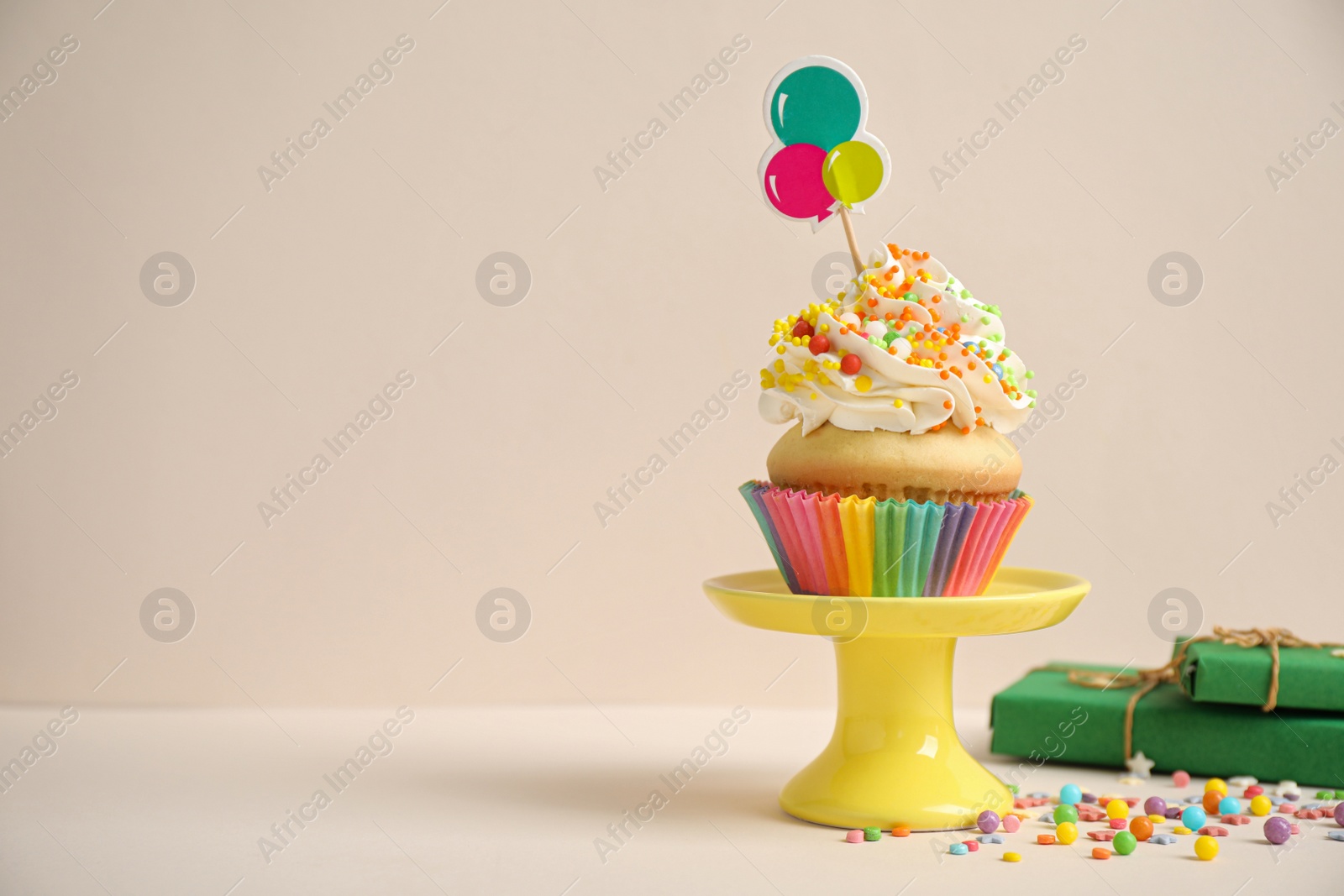 Photo of Birthday cupcake and gift boxes on beige background. Space for text