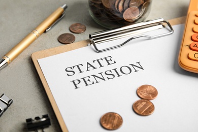 Photo of Paper with words STATE PENSION, coins, jar and pen on table