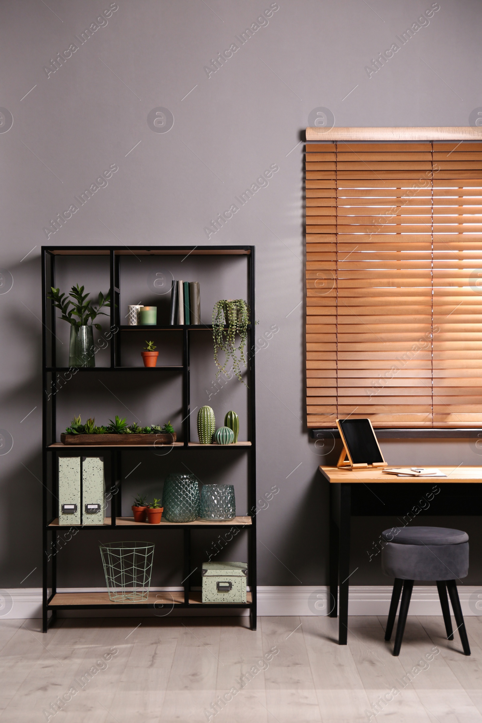 Photo of Stylish room with shelving and table. Interior design