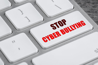 Image of Modern computer keyboard with phrase STOP CYBER BULLYING on white button, closeup