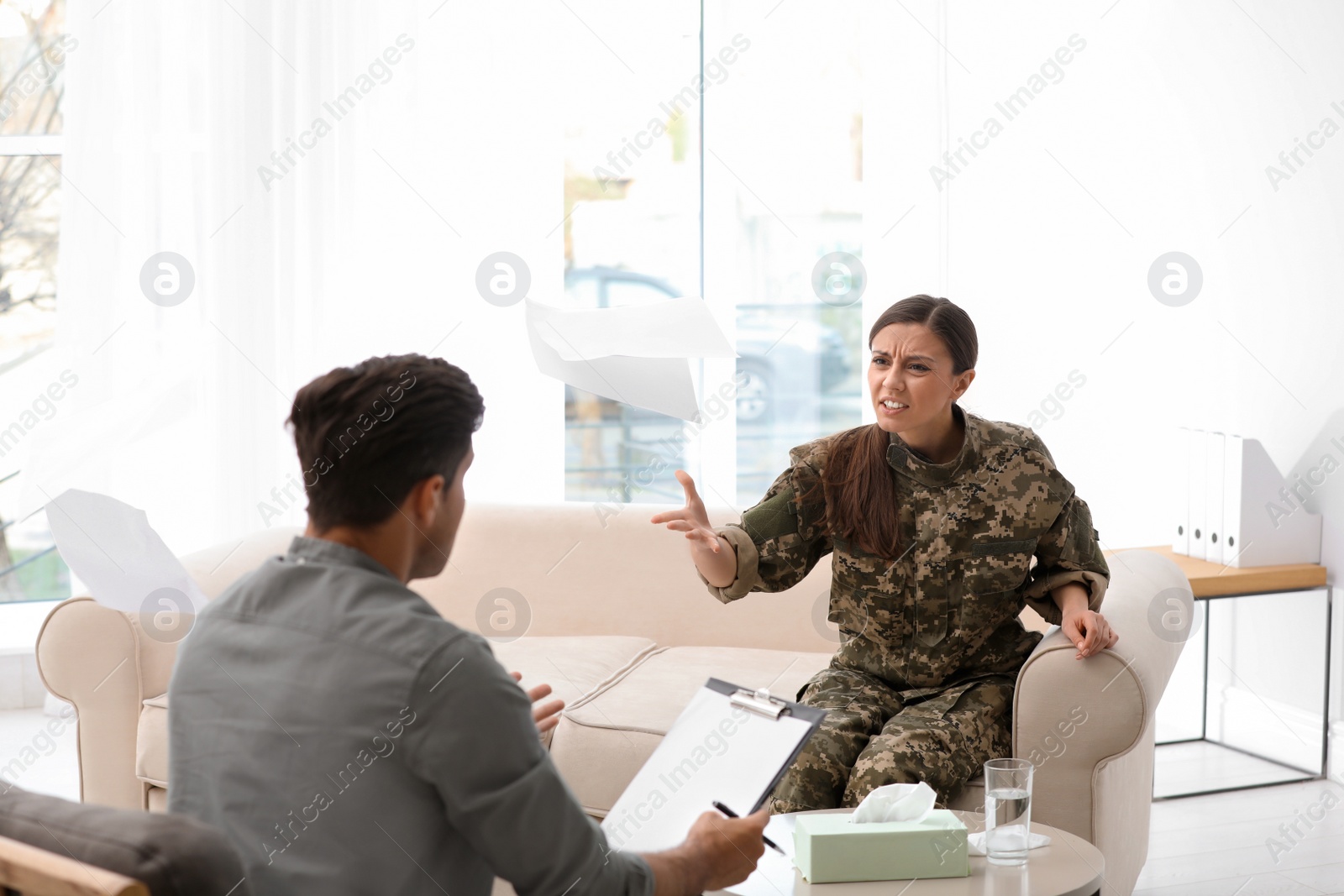 Photo of Psychotherapist working with female military officer in office