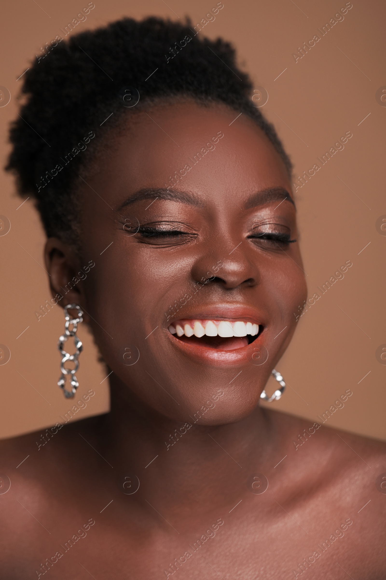 Photo of Fashionable portrait of beautiful happy woman on light brown background