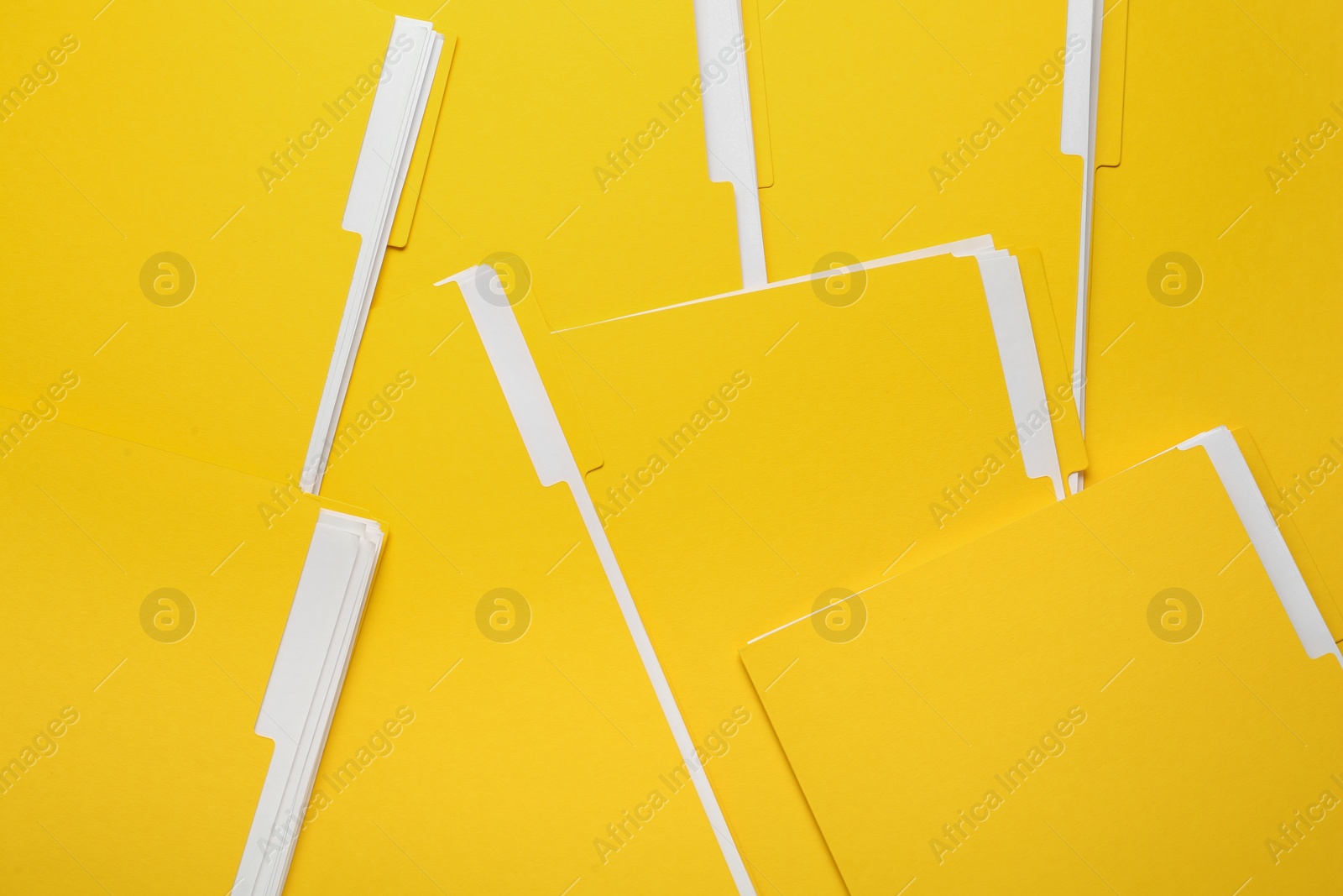 Photo of Many yellow files with documents as background, top view