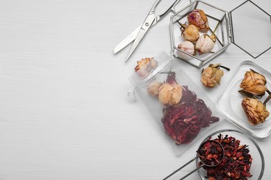 Scented sachet with dried flowers and scissors on white table, flat lay. Space for text