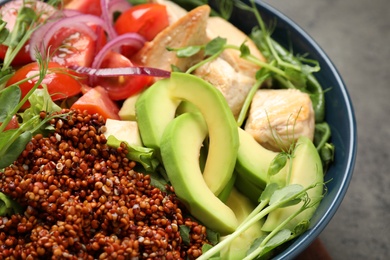 Photo of Delicious avocado salad with quinoa on grey table, closeup