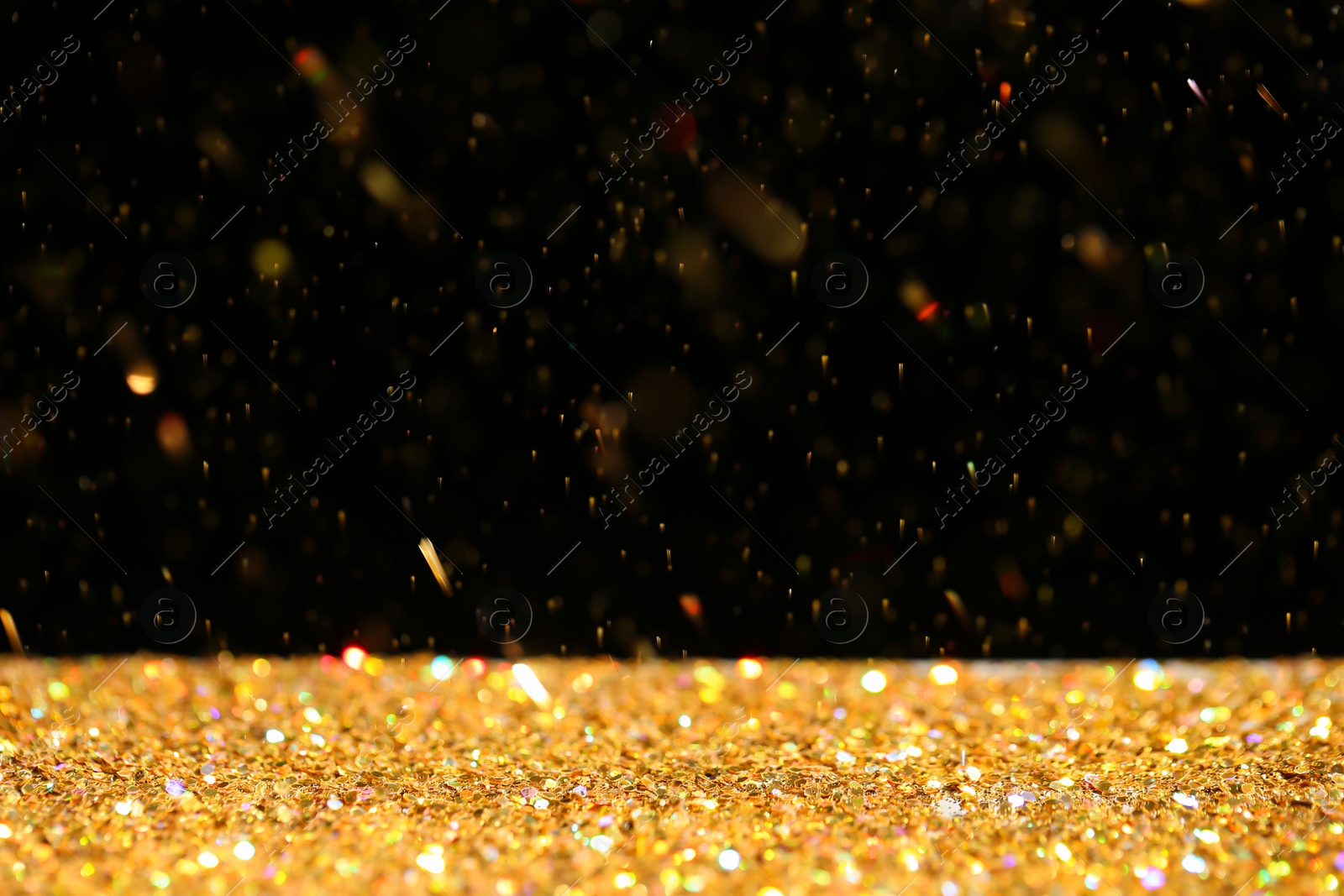 Photo of Many golden paillettes against black background. Space for text