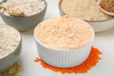 Photo of Different types of flour on white table, closeup