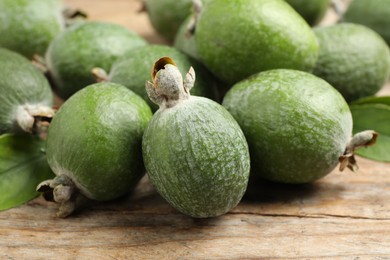 Photo of Fresh green feijoa fruits on wooden table, closeup