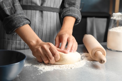 Photo of Woman kneading dough for pastry on table