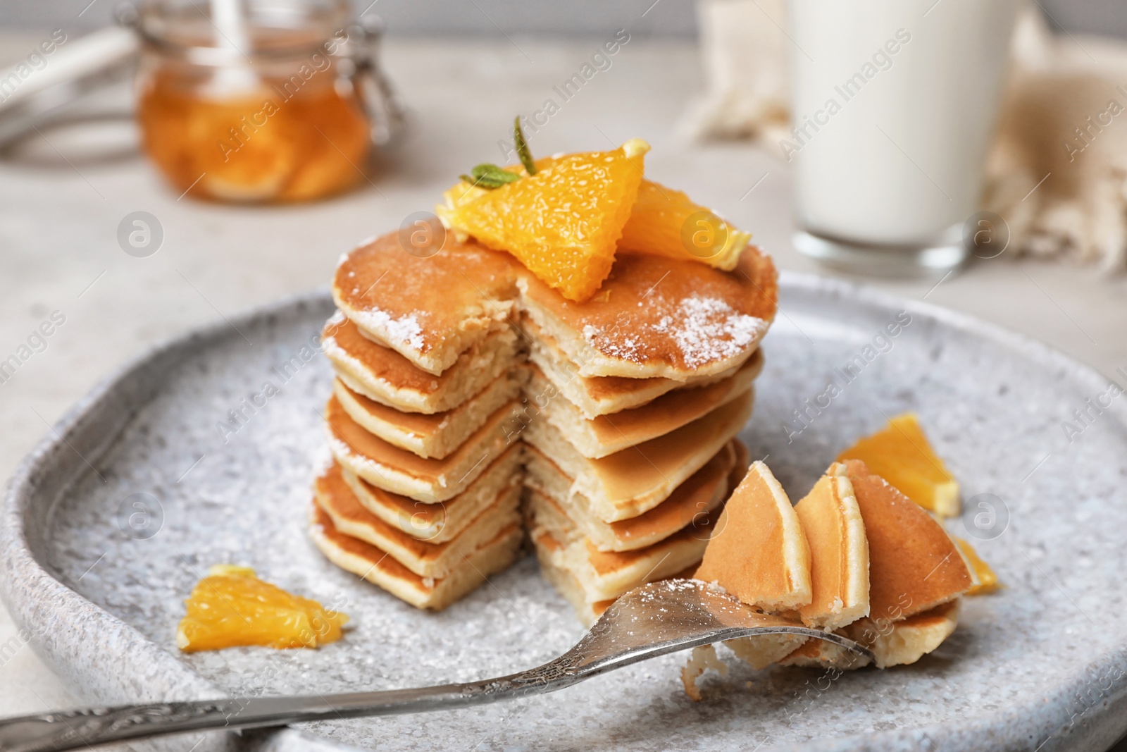 Photo of Tasty pancakes with orange on table