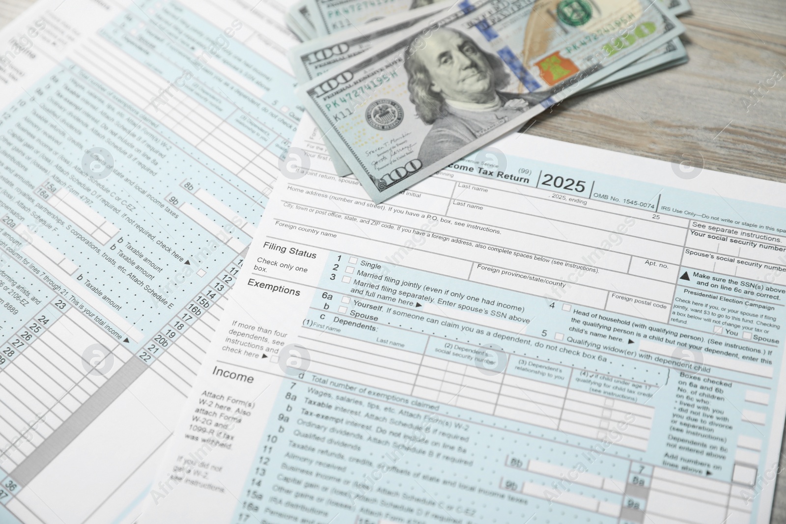 Photo of Payroll. Tax return forms and dollar banknotes on wooden table