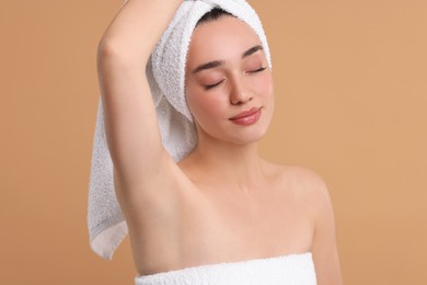 Photo of Beautiful woman showing armpit with smooth clean skin on beige background